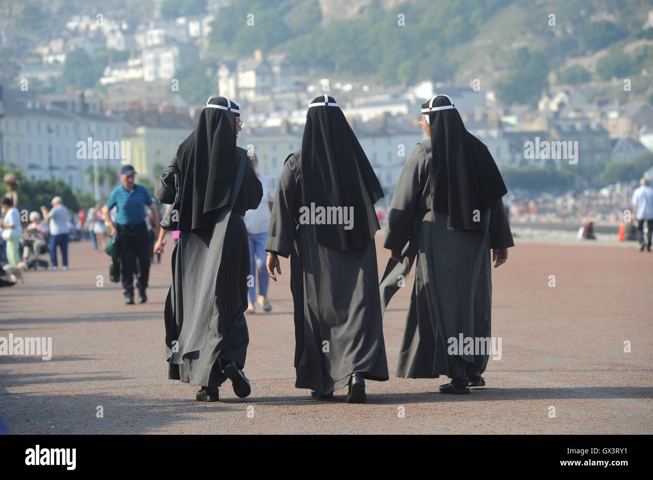 WOMEN IN RELIGIOUS DRESS WALKING RE RACE RACIST COMMUNITY MULTI CULTURAL BURKA STYLE COVERED HEAD DRESS INTEGRATION BRITISH UK Stock Photo