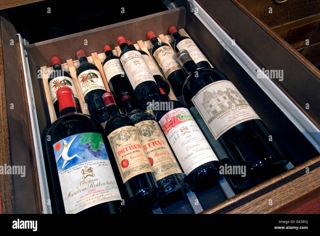 WINE BOTTLE LIBRARY COLLECTION Fine variety of luxury Bordeaux wines including Château Petrus from 1918 to 1989 in a private wine cellar collection Stock Photo