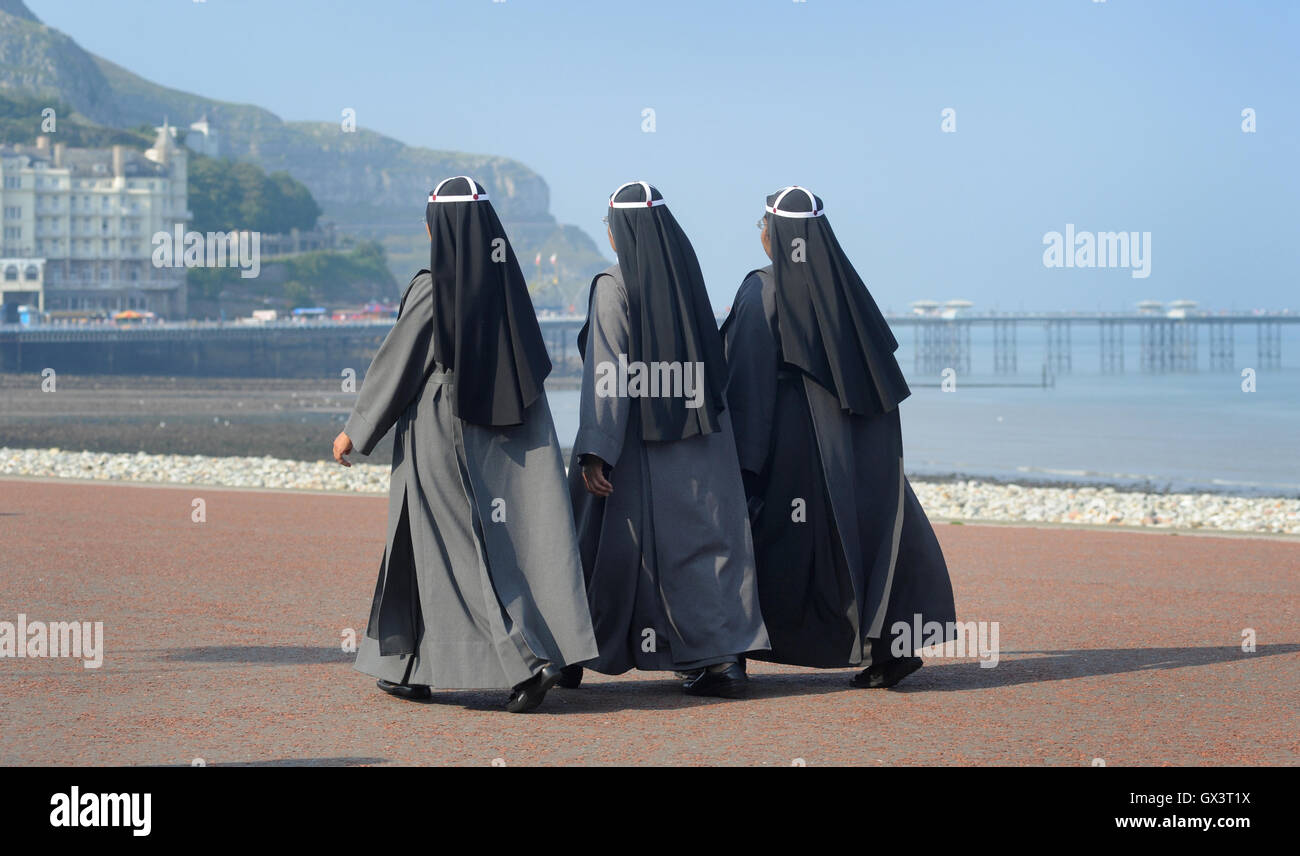 WOMEN IN RELIGIOUS DRESS WALKING ON SEAFRONT RE ETHNIC DIVERSITY MULTI CULTURAL COMMUNITY BURKA STYLE HEAD COVERING COVERED UK Stock Photo