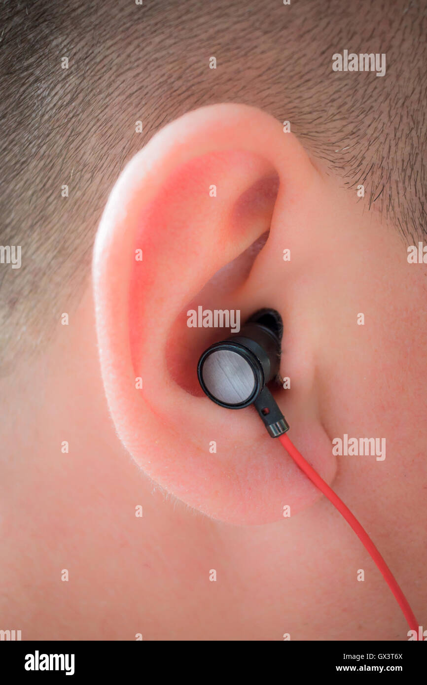 Male human ear with red wire earphone Stock Photo