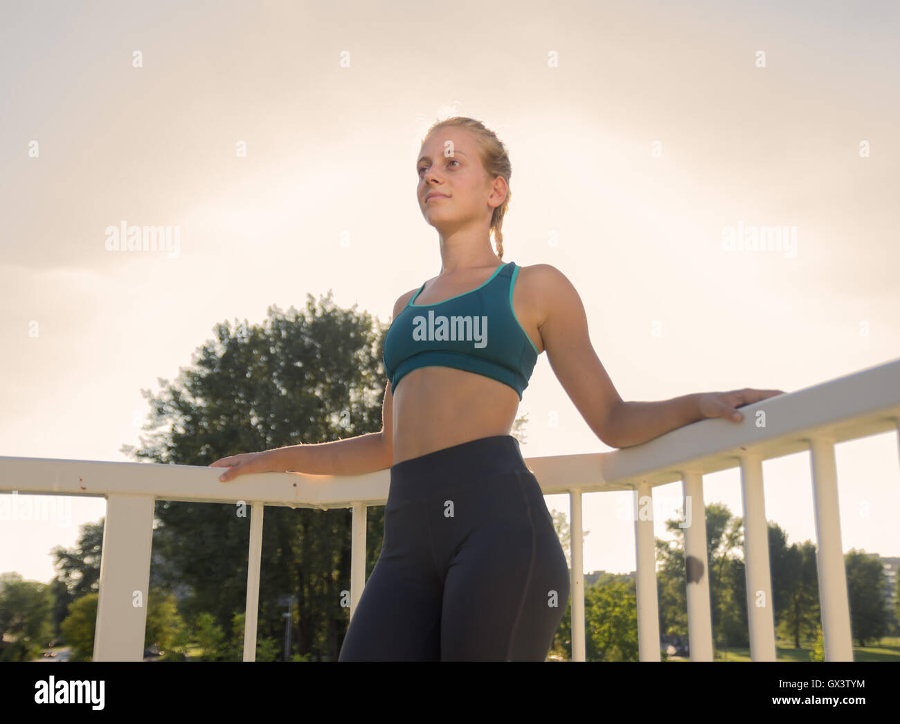 young teenage girl posing athlete slim fit sport clothes tights bra  outdoors sunny day Stock Photo - Alamy