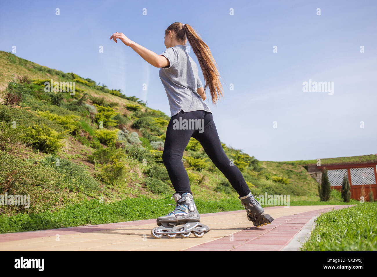 Beautiful teenage girl rollerskating in park Stock Photo