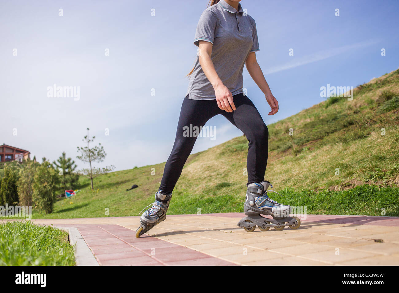 Beautiful teenage girl rollerskating in park Stock Photo