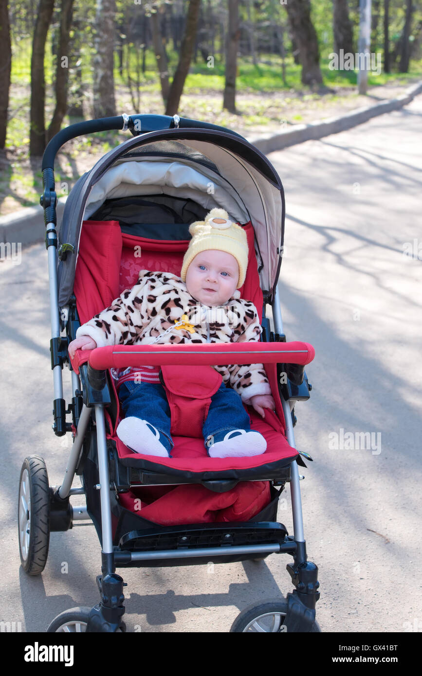 Happy Baby sitting stroller on nature Stock Photo - Alamy