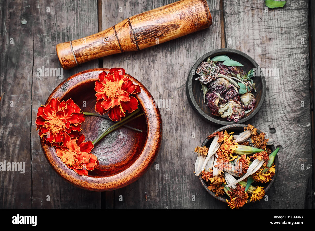 Mortar with healing flowers, plant marigolds and pestle Stock Photo - Alamy