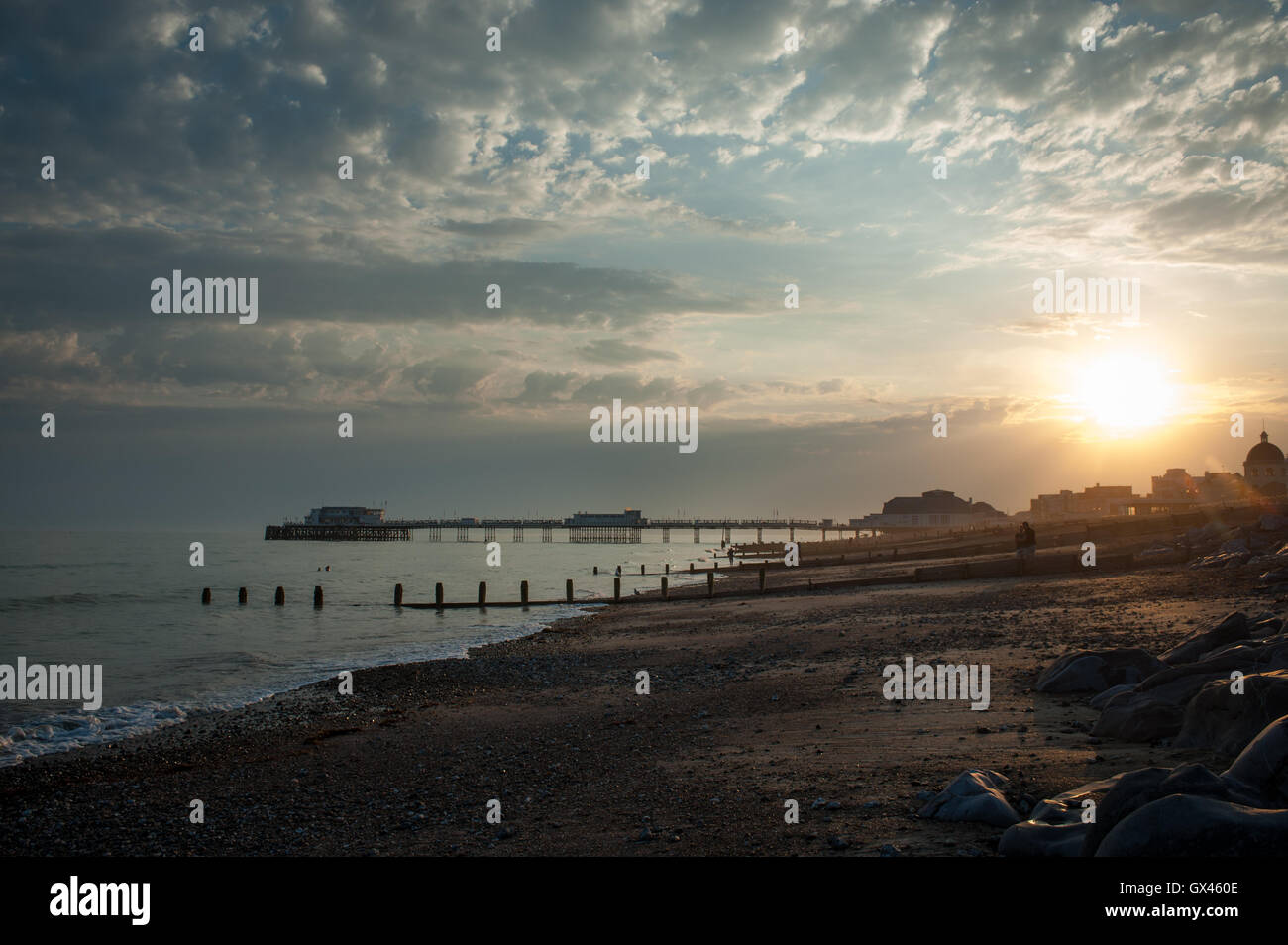 ​A beautiful sunset over the beach, sea and Worthing Pier in Worthing, West Sussex, England. Stock Photo