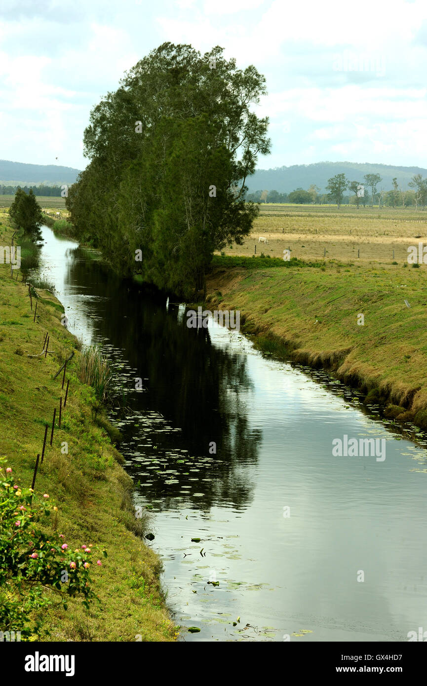 An irrigation channel runs through farmland in Northern NSW Australia Stock Photo