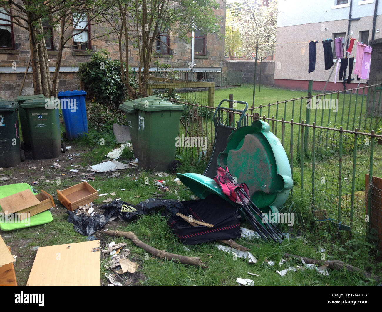Household garbage refuse strewn in back lane, in Glasgow, Scotland