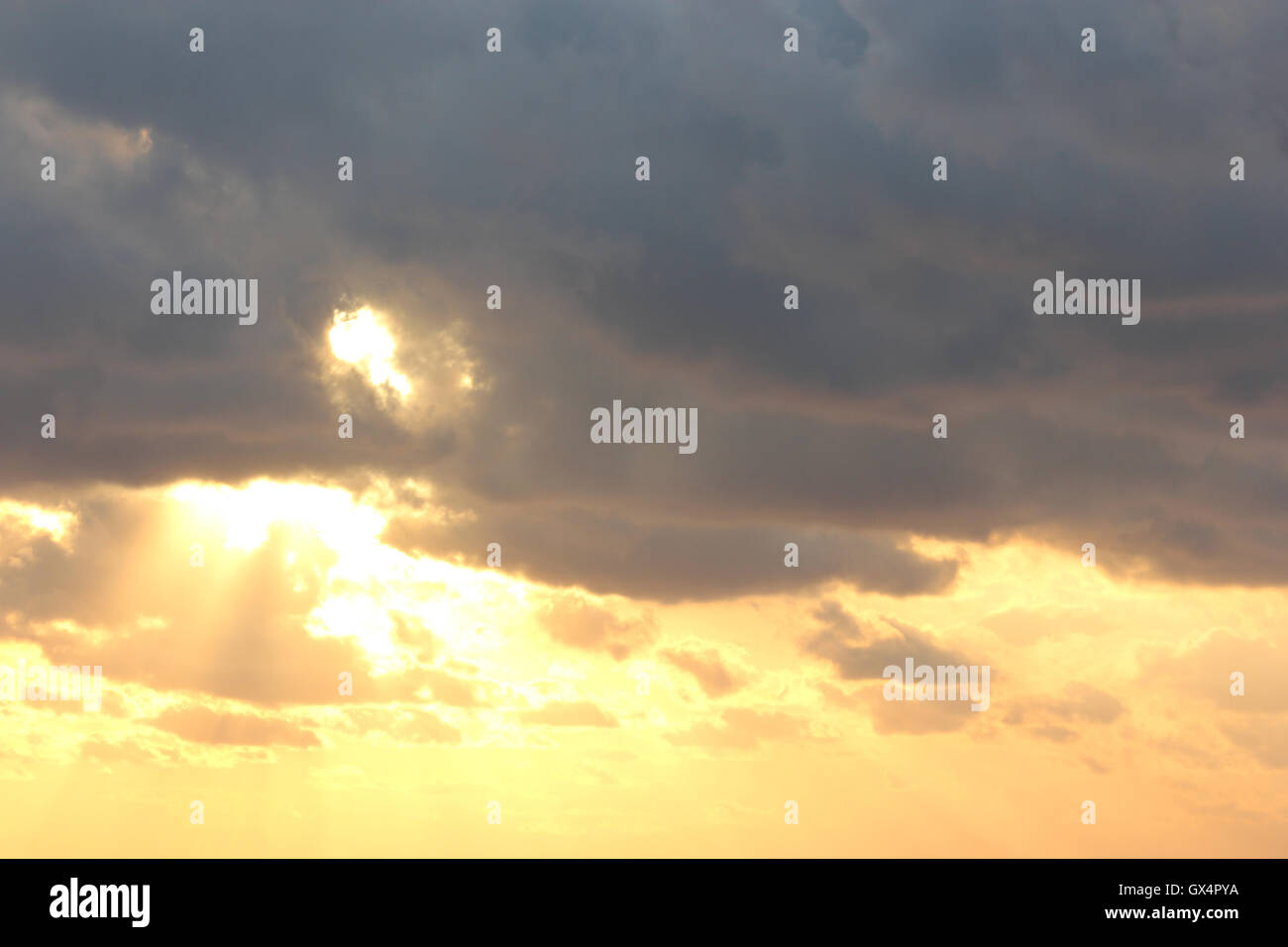 a beautifully moody sky with the sun behind the clouds, at sunset Stock Photo