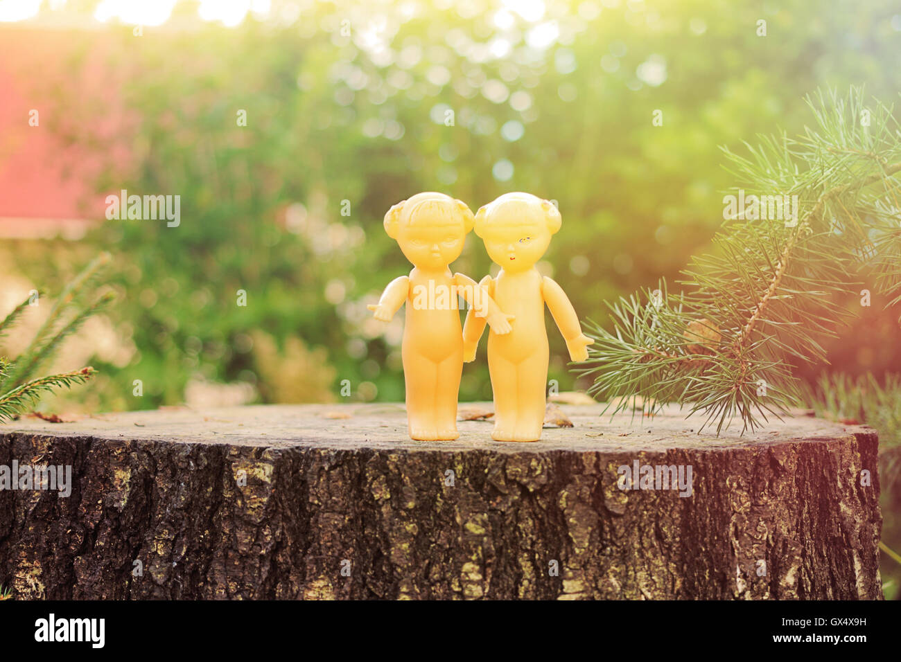 Retro dolls - twins standing on the stump. Mass production made in USSR, 1970-1980. Stock Photo