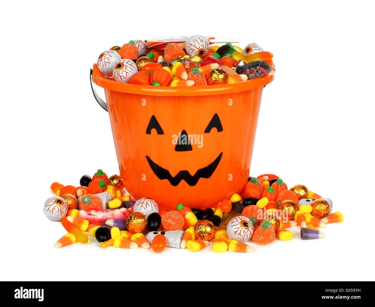 Halloween Jack o Lantern pail with pile of candy over white Stock Photo