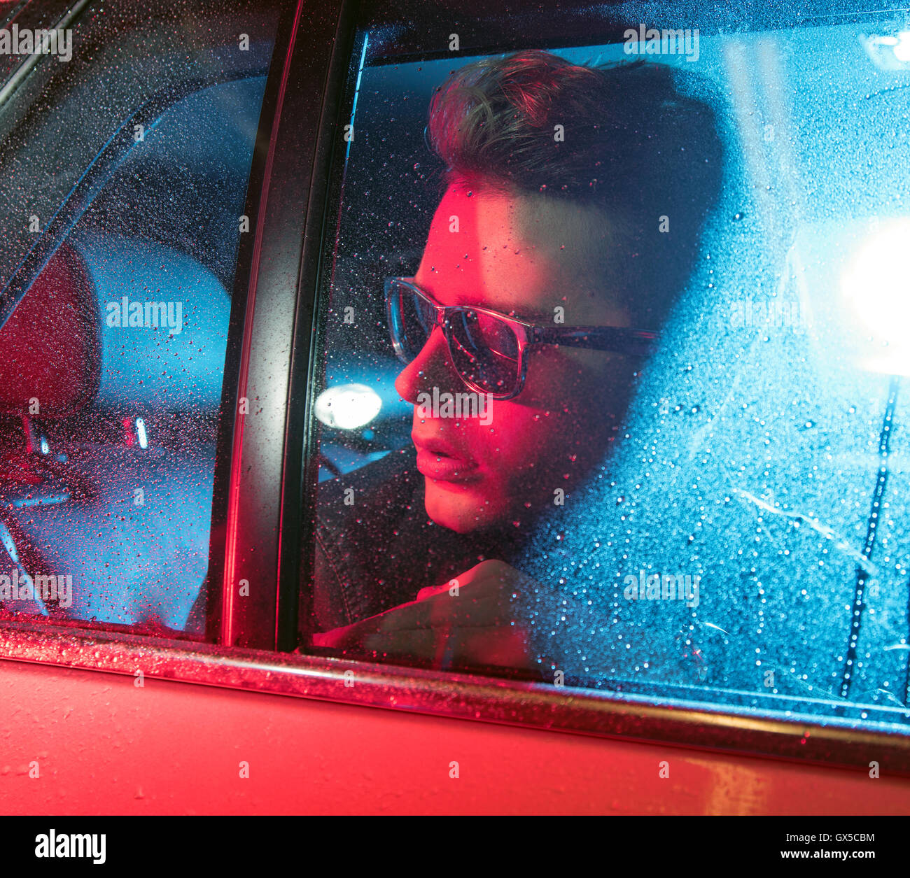 Conceptual image of a handsome man sitting in the red car Stock Photo ...