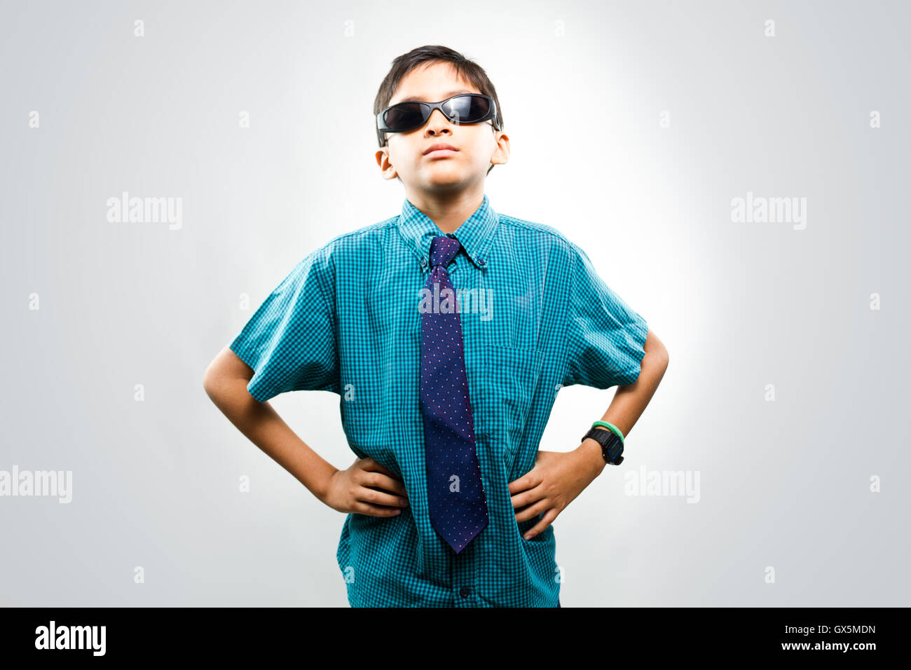 Portrait of a boy wearing sunglasses looking at camera in light grey background Stock Photo