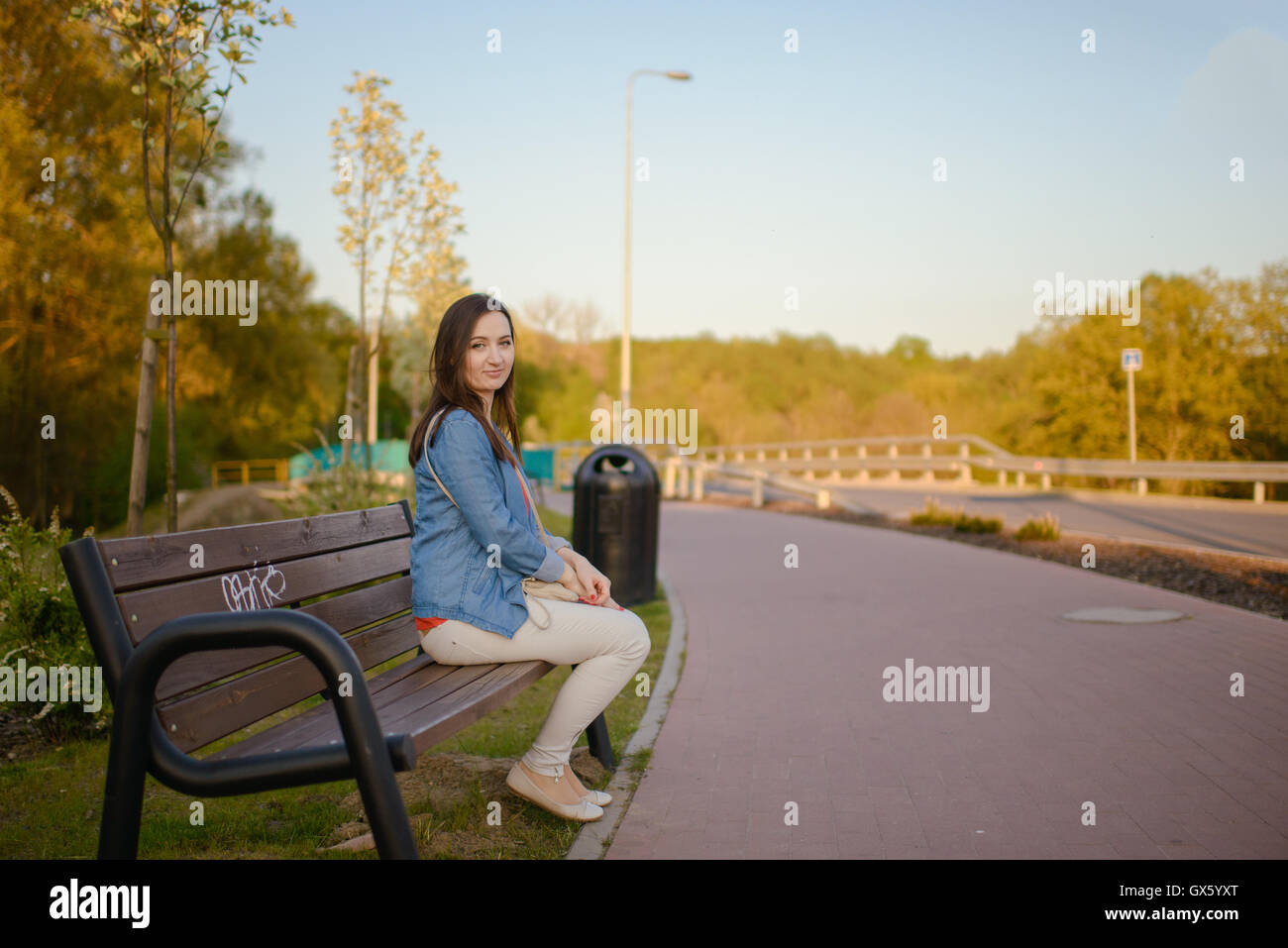 The beautiful young city woman sits on a bench in the city Stock Photo ...
