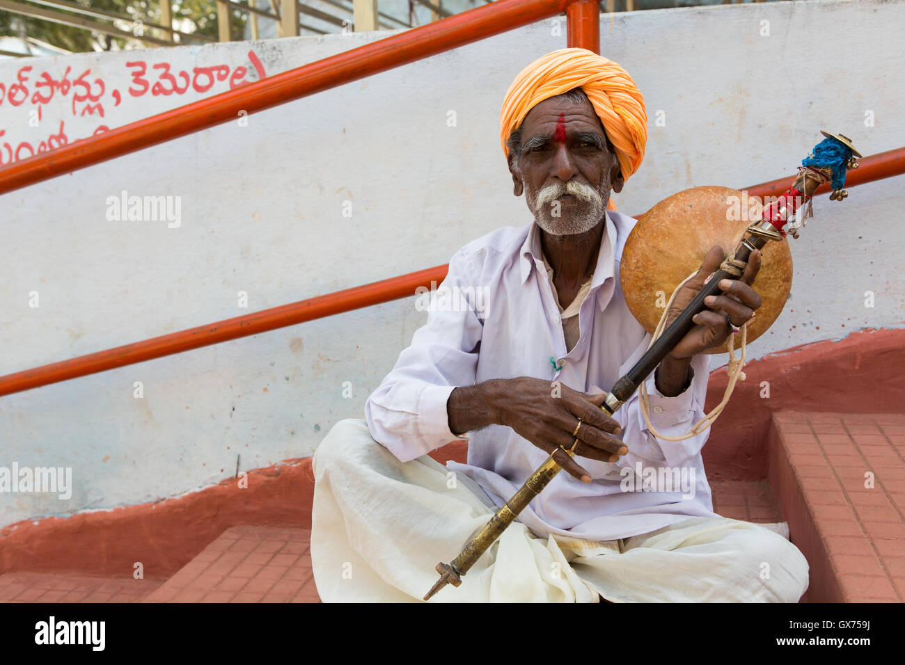 Old Indian man with a musical instrument at Anantha Padmanabha Swamy Temple Stock Photo