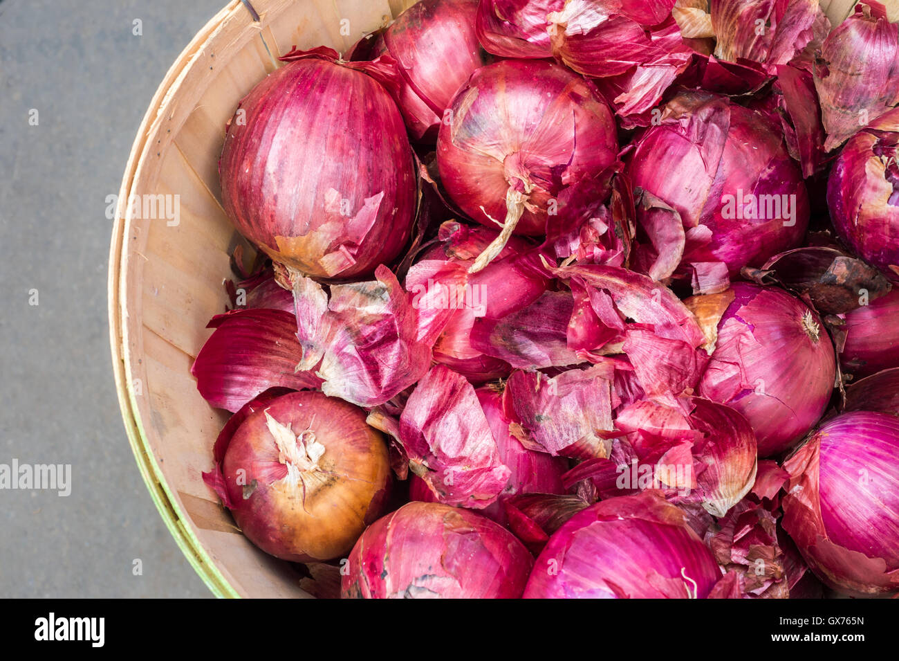 Red onions in a basket at the market Stock Photo
