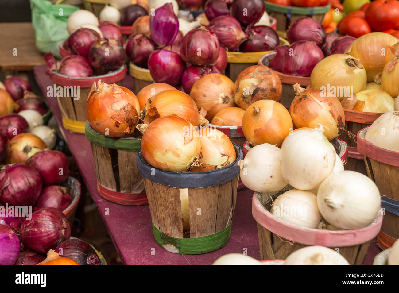Different types of onions in baskets at the market Stock Photo