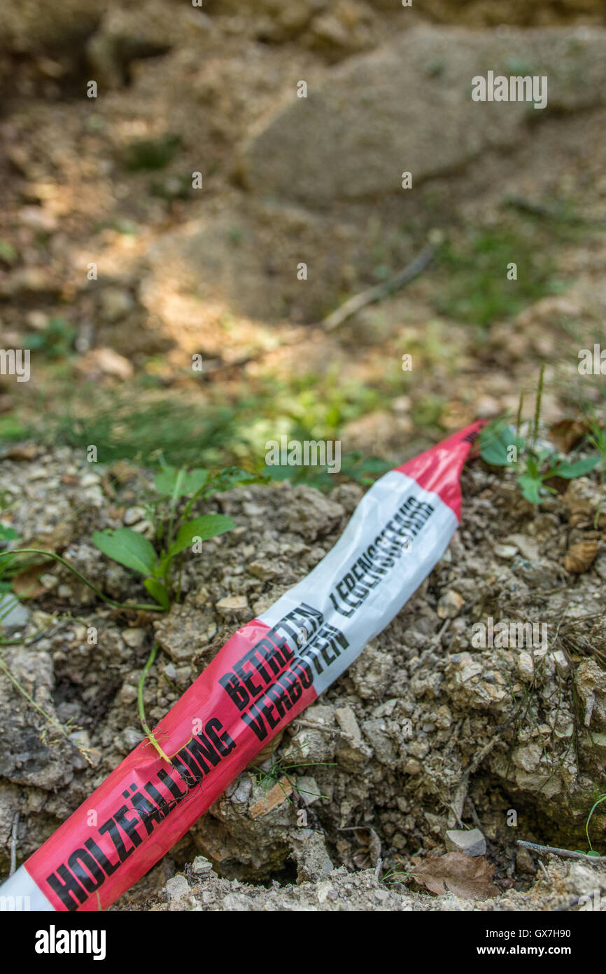 German barrier tape in forest - deforestation, keep off, mortal danger Stock Photo