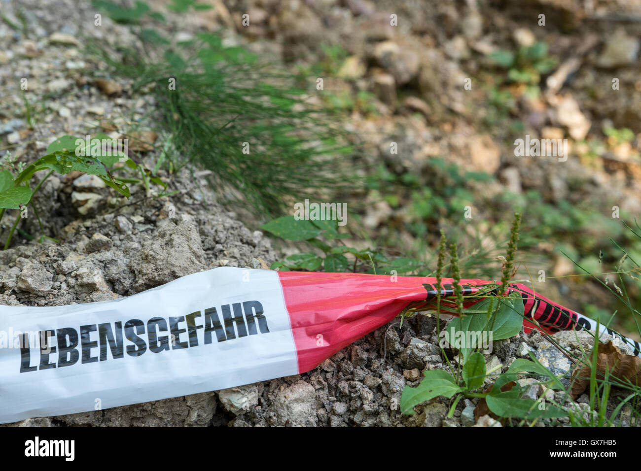 German barrier tape in forest - Mortal Danger Stock Photo