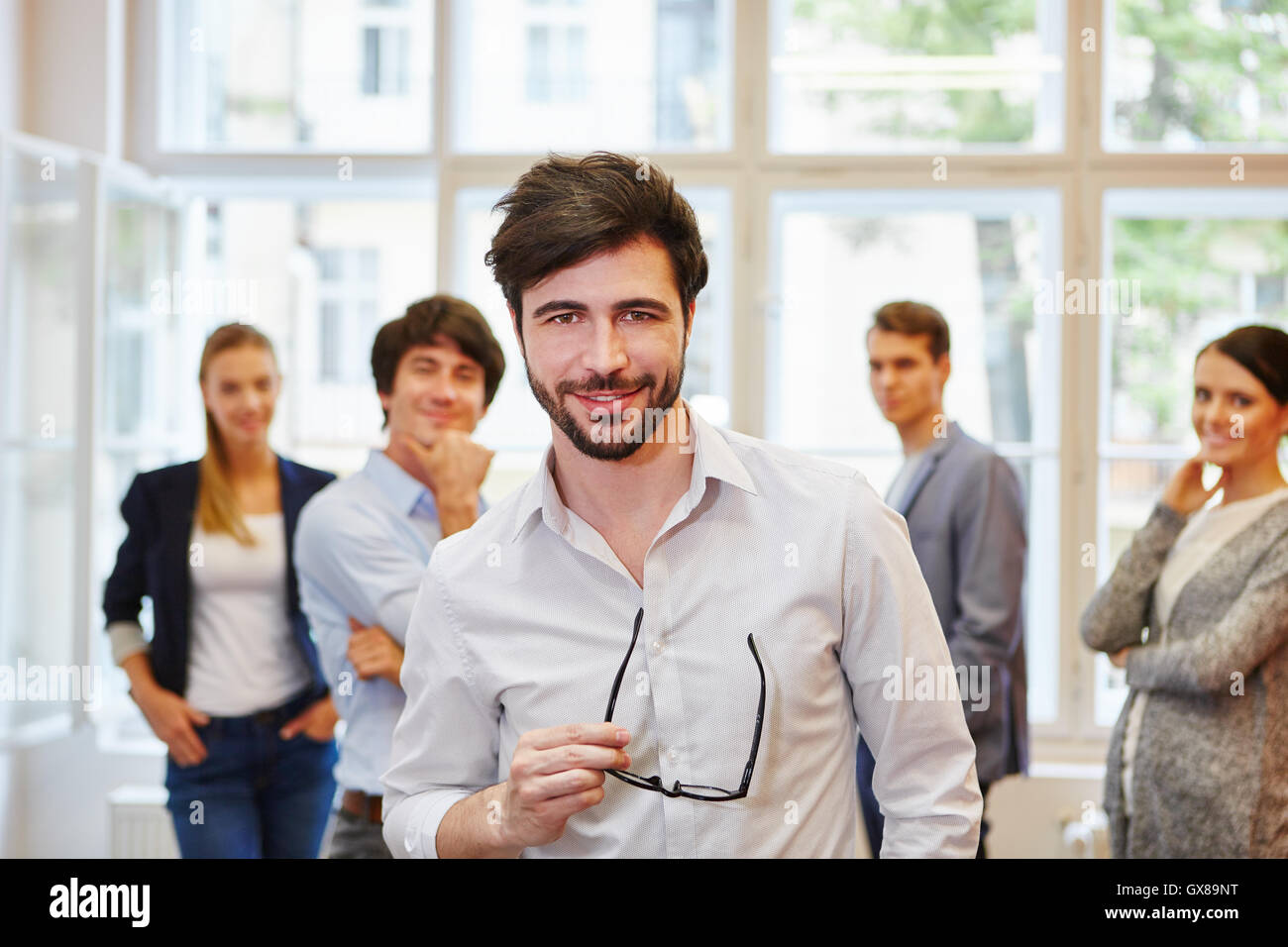 Businessman standing proud in front of start-up team Stock Photo - Alamy