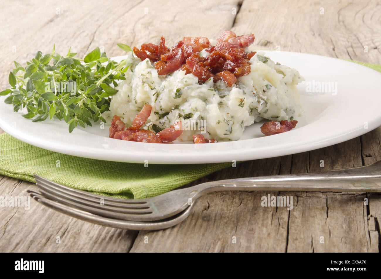 herb mashed potatoes with fried bacon Stock Photo