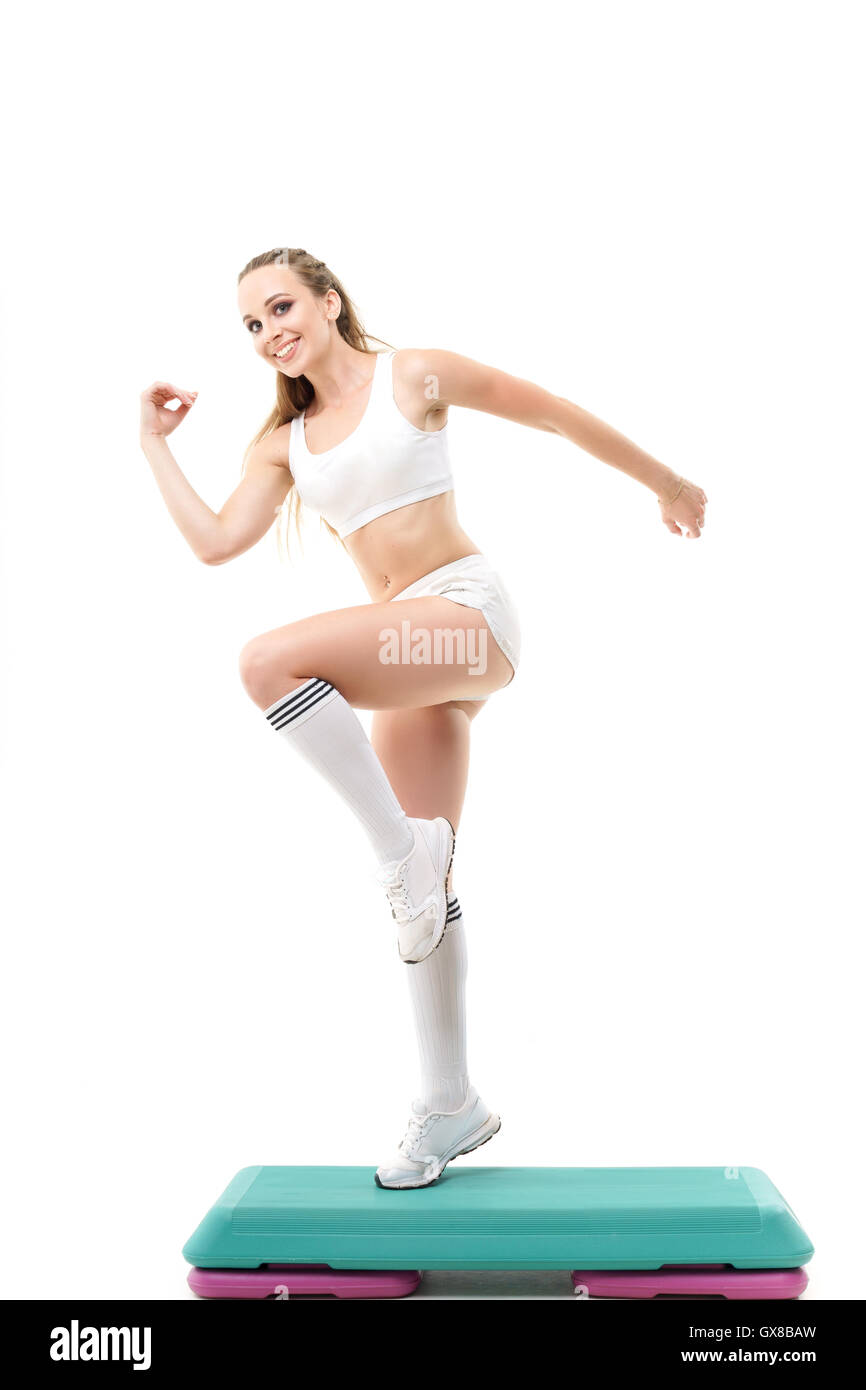 Concepts: healthy lifestyle, sport. Happy beautiful woman fitness trainer working out step aerobics isolated on white background Stock Photo