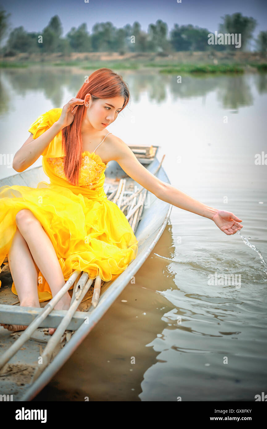 Portrait of Asia Beautiful woman in yellow dress sitting on boat Stock ...