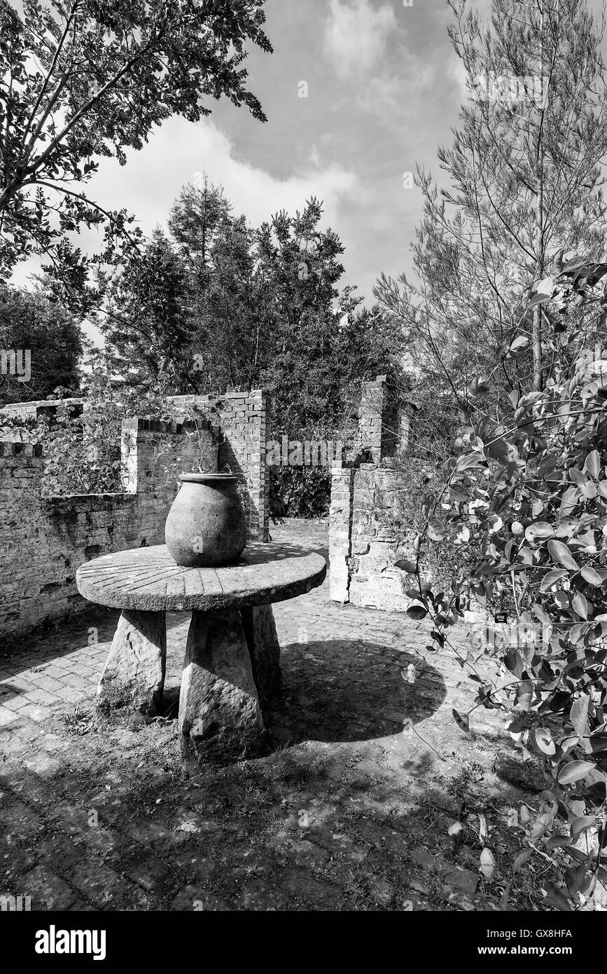 Old potting table and pots in brick potting shed in black and white Stock Photo
