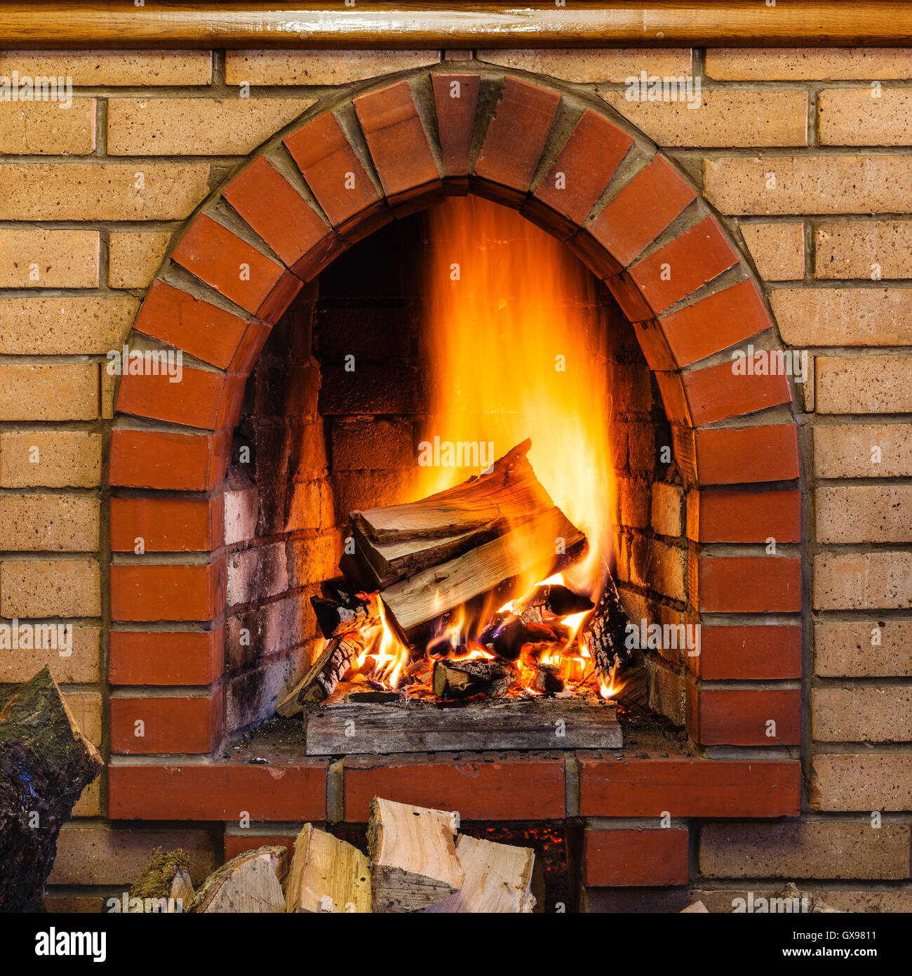 wood burning in indoor brick fireplace in country cottage Stock Photo