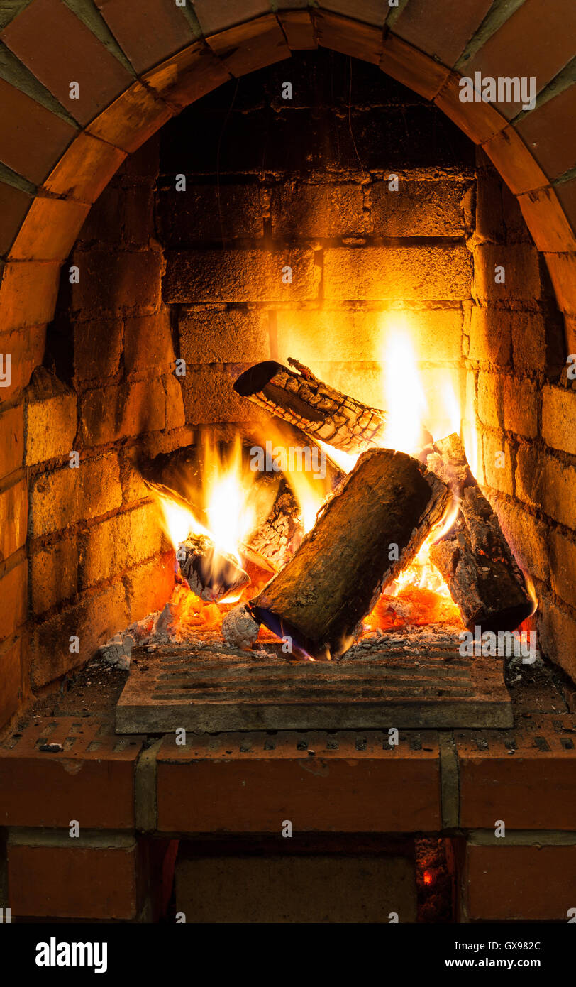 fire in fire-box of fireplace in country cottage Stock Photo
