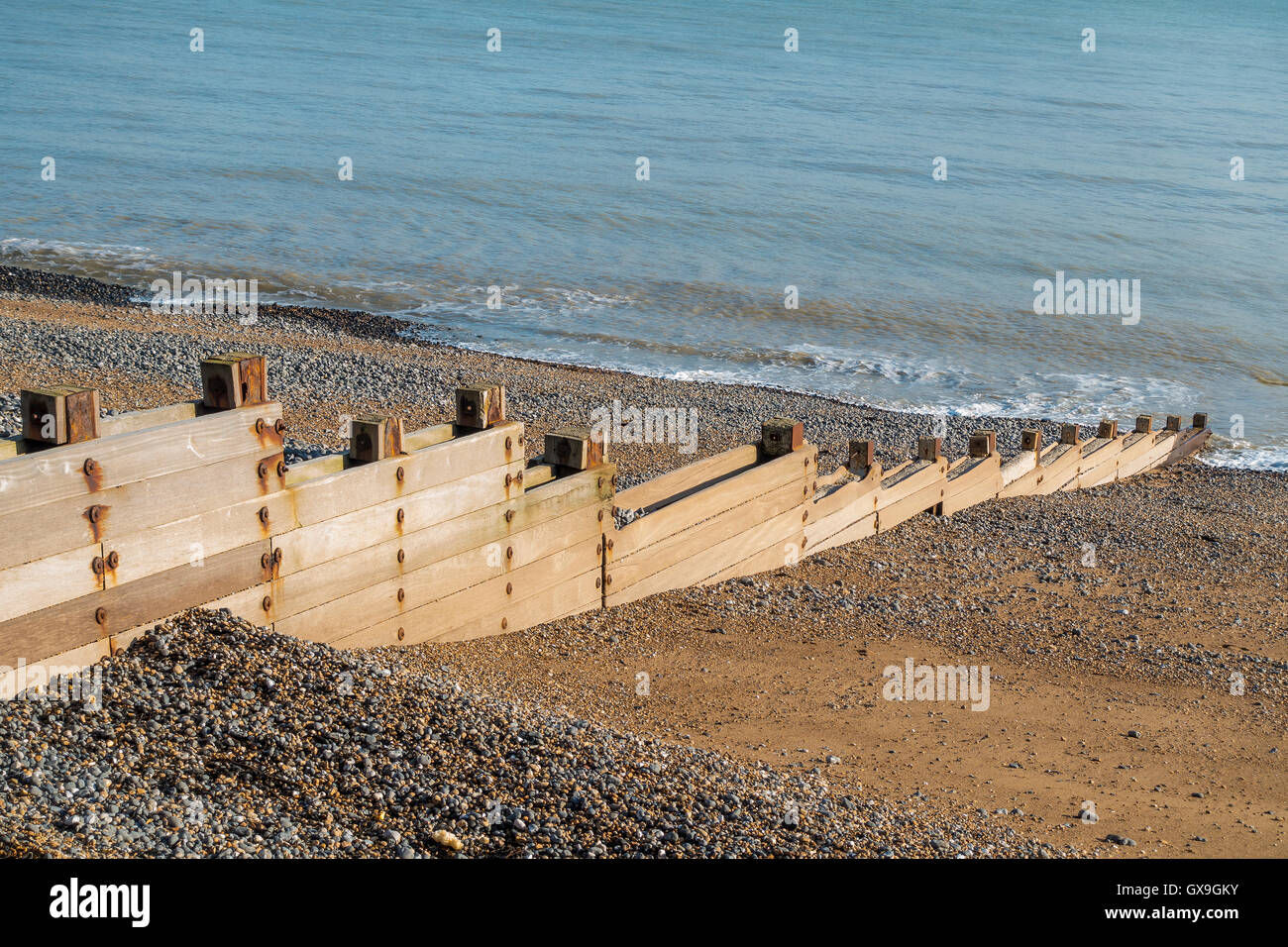 Wooden Groyne on Pebble Beach to Prevent Longshore Drift Stock Photo