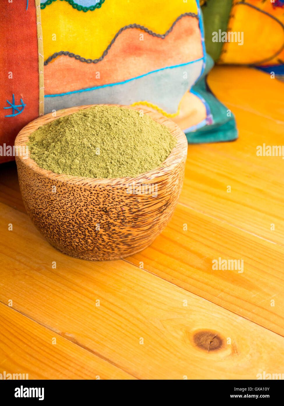 Henna powder hair colourant in the coconut bowl on the bright pillows background Stock Photo
