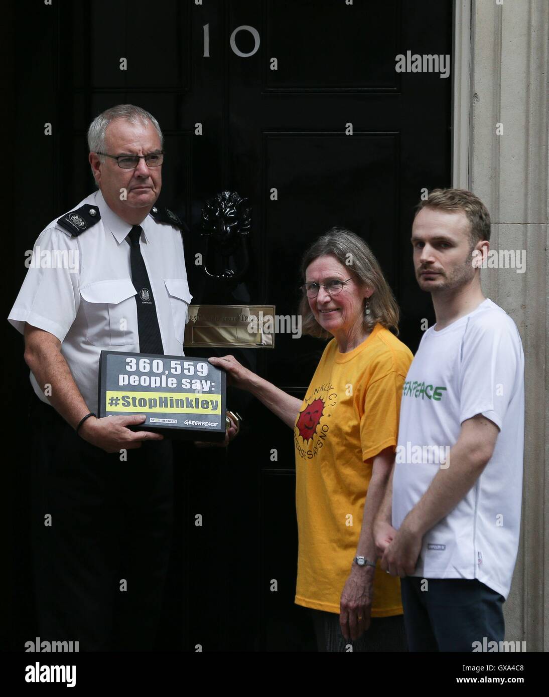 Stop Hinkley campaigner Sue Aubrey (centre) and Richard Casson (right) from Greenpeace UK hand a petition to Downing Street in London, calling on Prime Minister Theresa May to drop Hinkley and invest in renewable power instead. Stock Photo