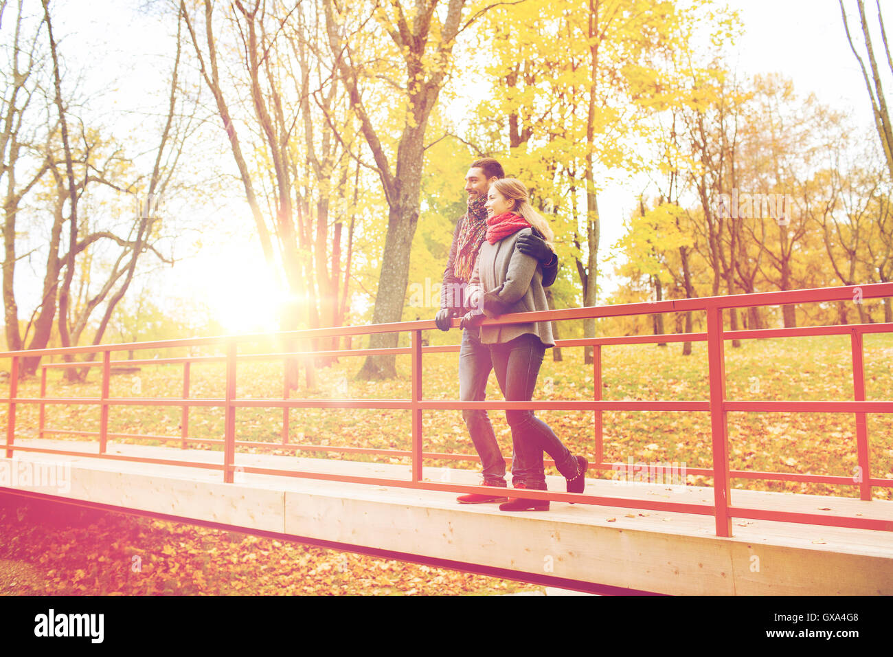 smiling couple hugging on bridge in autumn park Stock Photo - Alamy