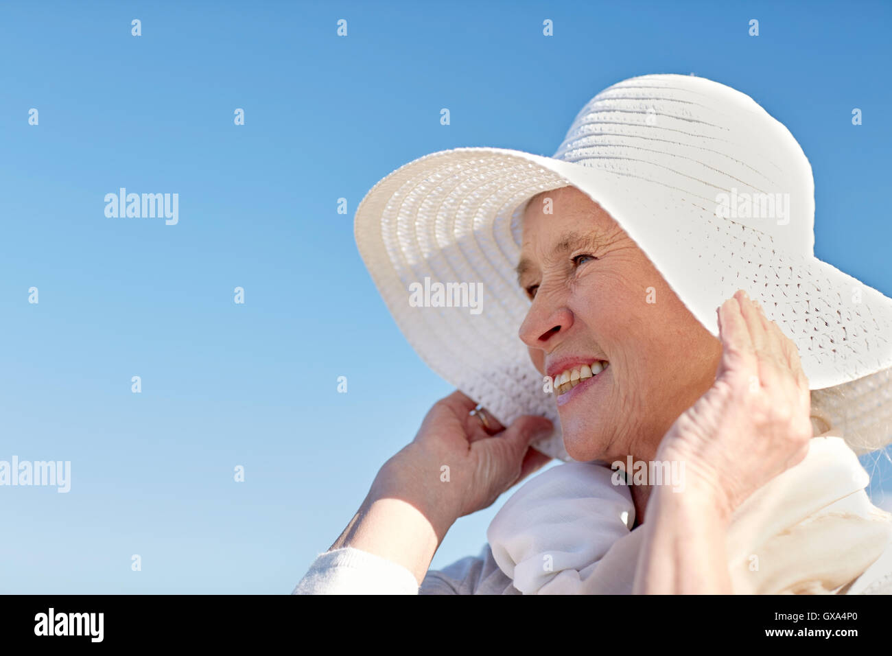 Mature woman sun hat smiling beach hi-res stock photography and images ...