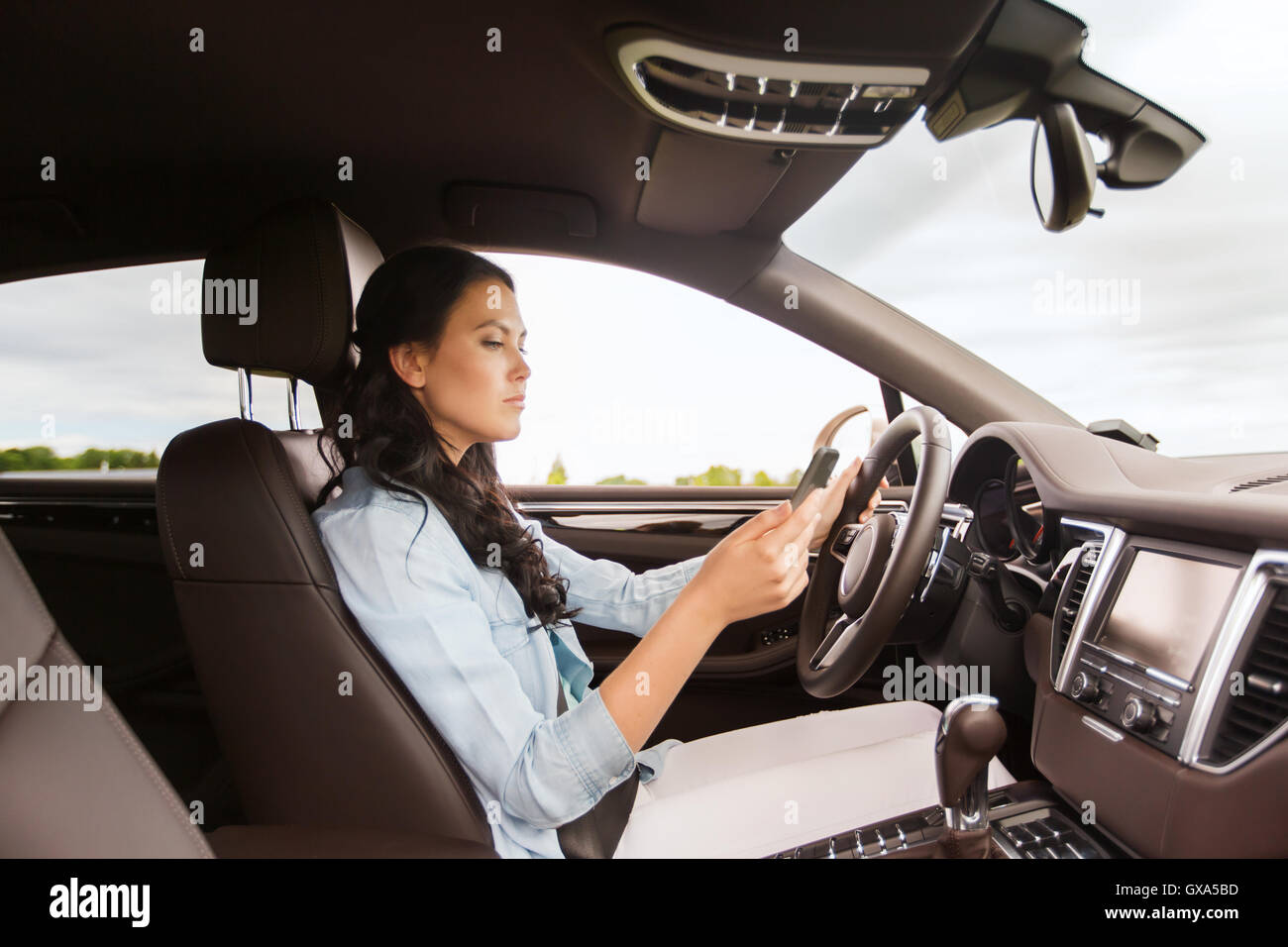woman driving car with smarhphone Stock Photo