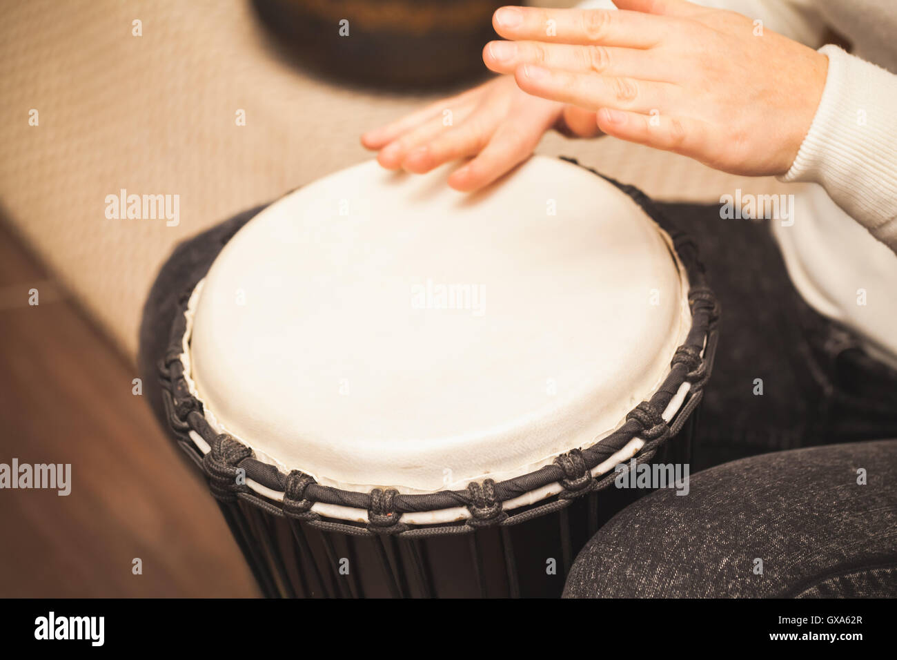 Drummer plays on small African drum, closeup photo with selective focus Stock Photo