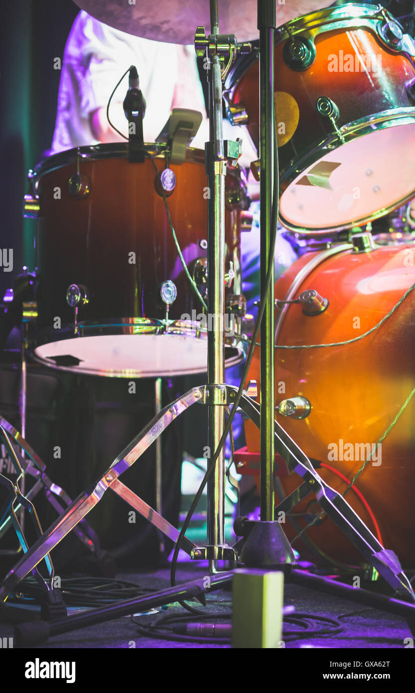 Drum set on a stage with colorful illumination, rock music photo background with tonal correction filter Stock Photo