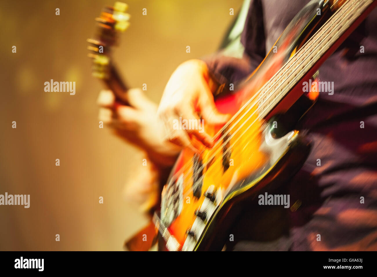 Colorful blurred rock music background, guitar players on a stage, motion blur effect and  retro tonal correction filter, old in Stock Photo