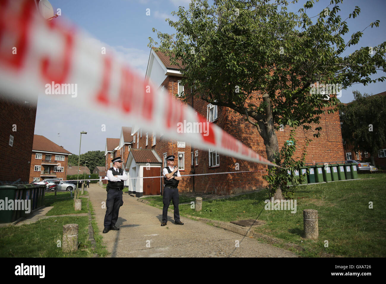 Police officers utside flats in in Elmshurst Crescent in East Finchley, north London where Anny Ekofo, 52, and her nephew Bevely, 21, where found dead with gunshot wounds. Stock Photo