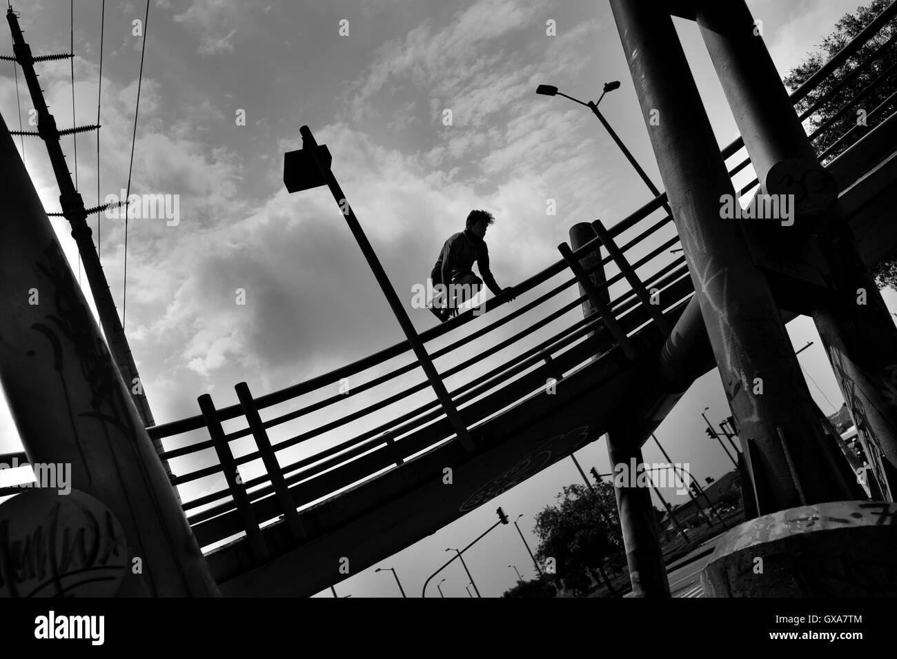 Steven Mantilla, a freerunner from Tamashikaze team, jumps over the footbridge railing in Bogotá, Colombia. Stock Photo