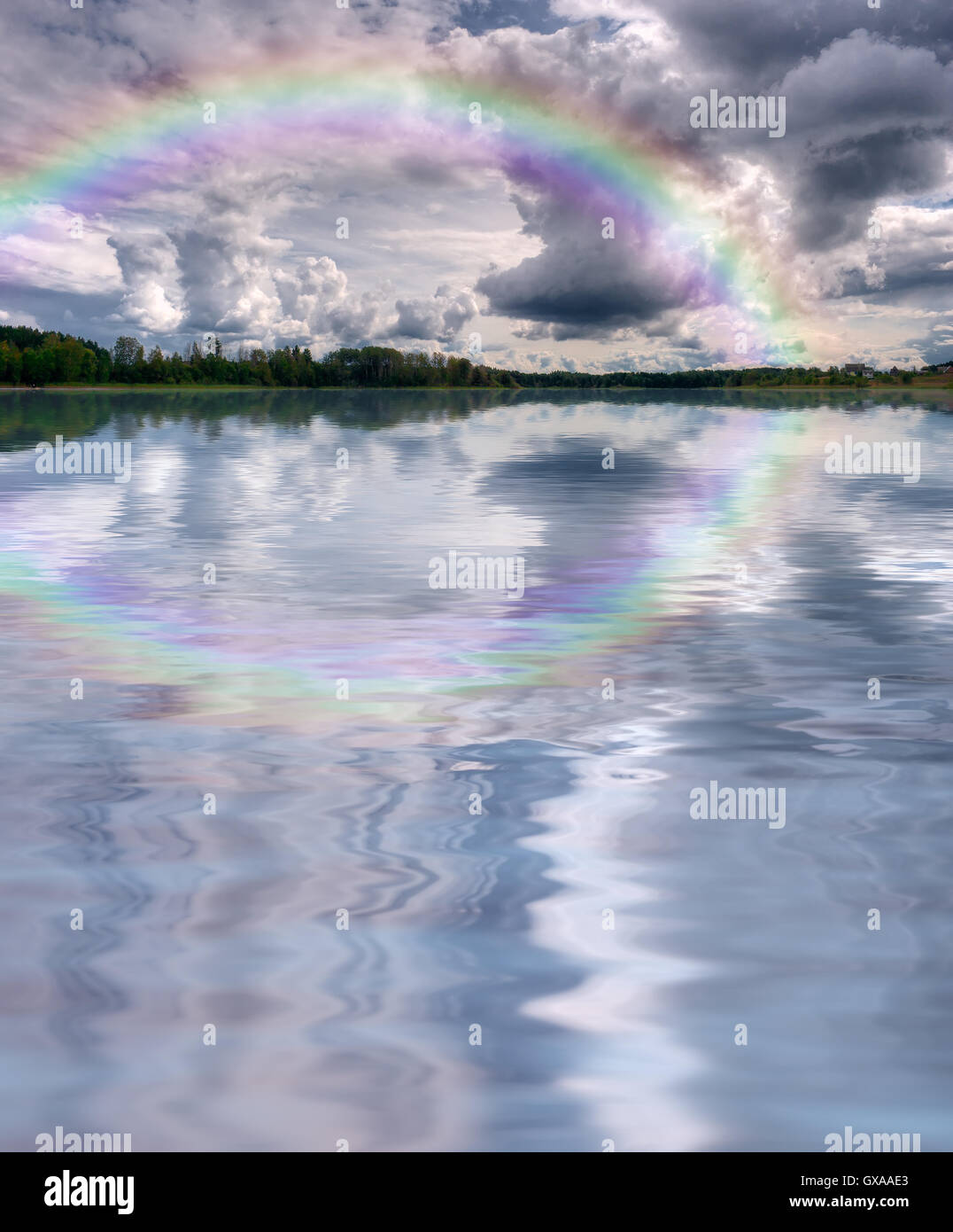 Summer nature landscape: shore with forest (trees) and sky with cumulus clouds and rainbow reflected in the lake (river) water Stock Photo