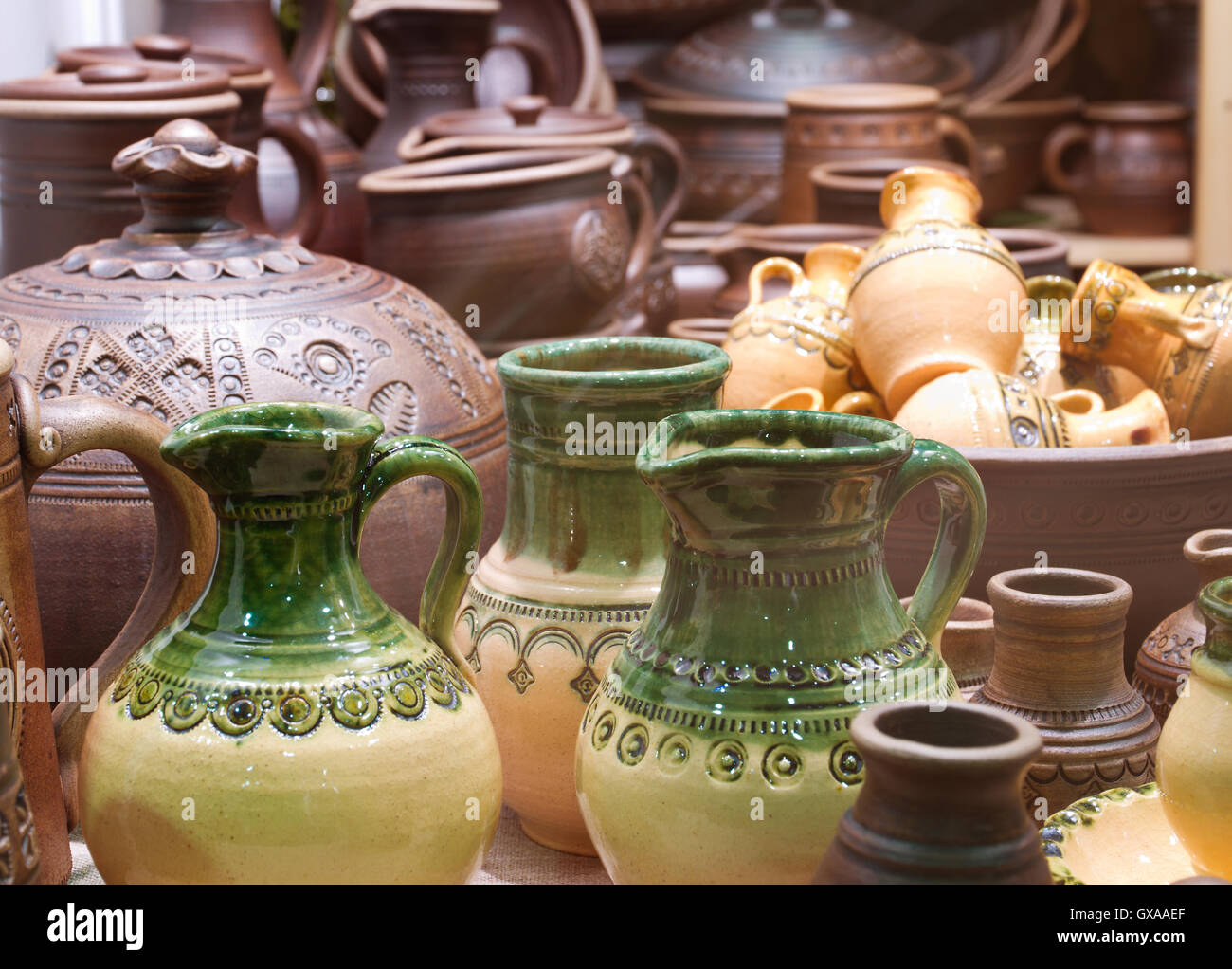 Handmade traditional russian ceramics (crockery, things, ware, jugs, pots) on the shopboard at the flea market in Moscow Stock Photo