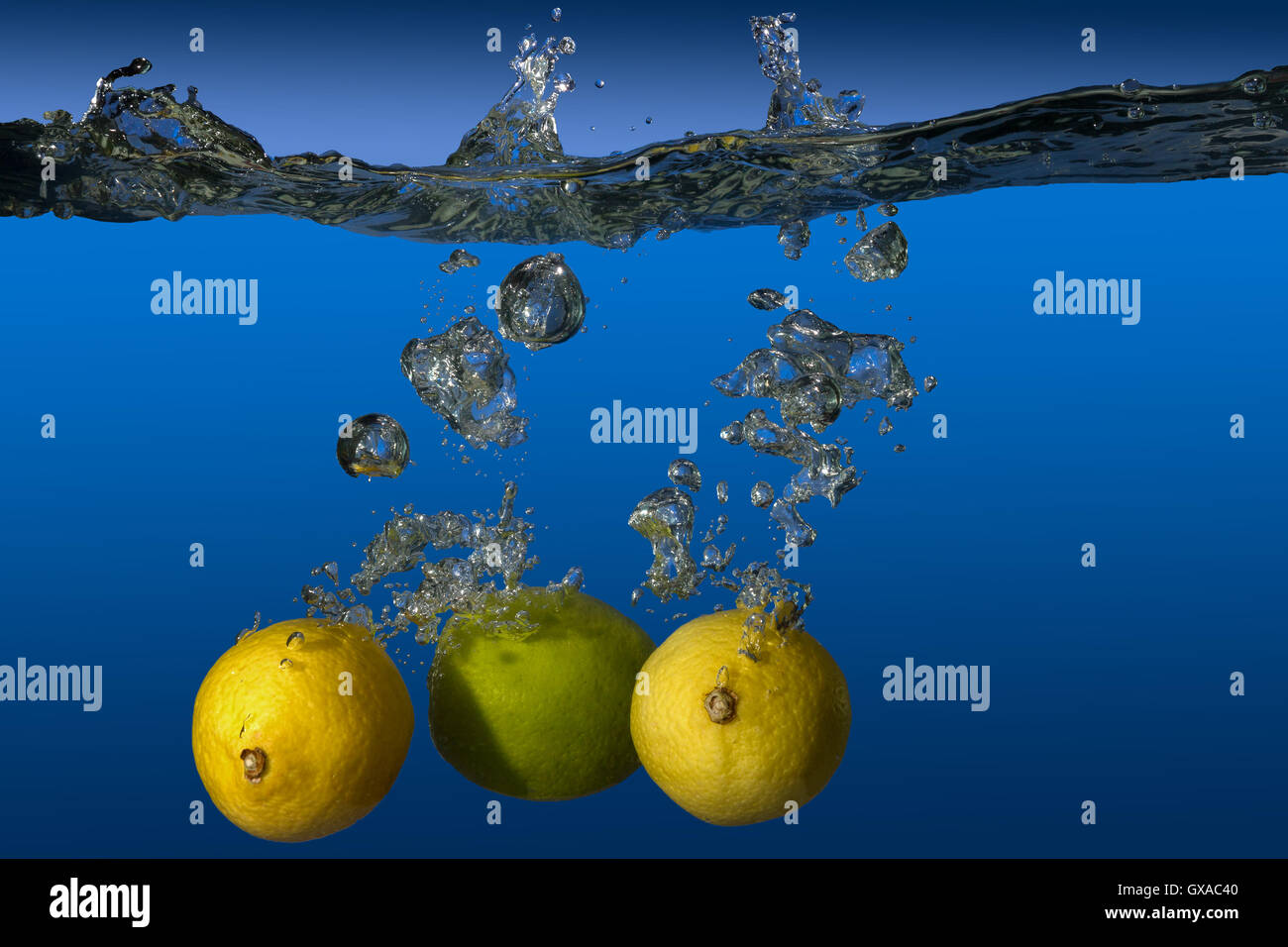 tropical fruit limes and lemons dropped in water Stock Photo Alamy