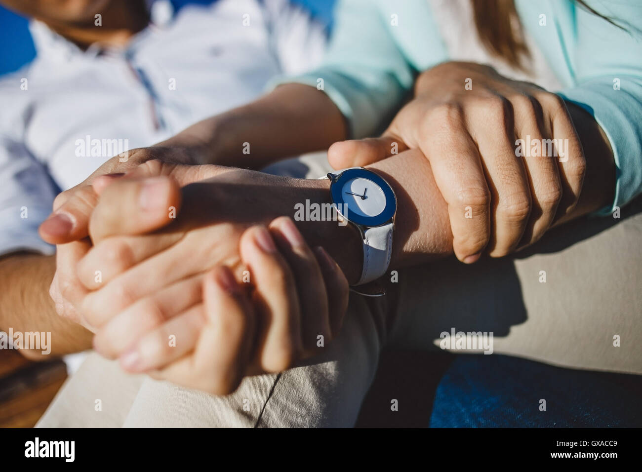 Couple  holding hands with watches in sunny day. Stock Photo