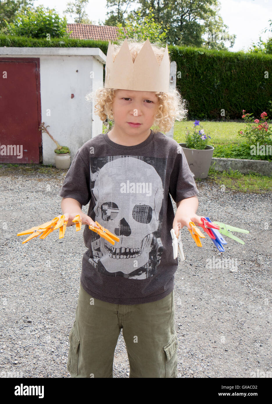 A Little Boy With Blond Curly Hair Played With Laundry Pins Stock