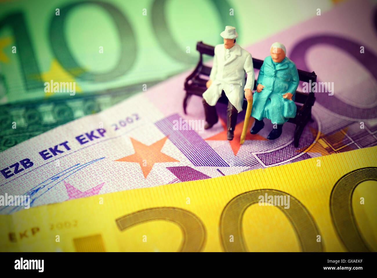 Seniorenpaar sitzt auf Geldscheinen, Symbolfoto Rente Stock Photo