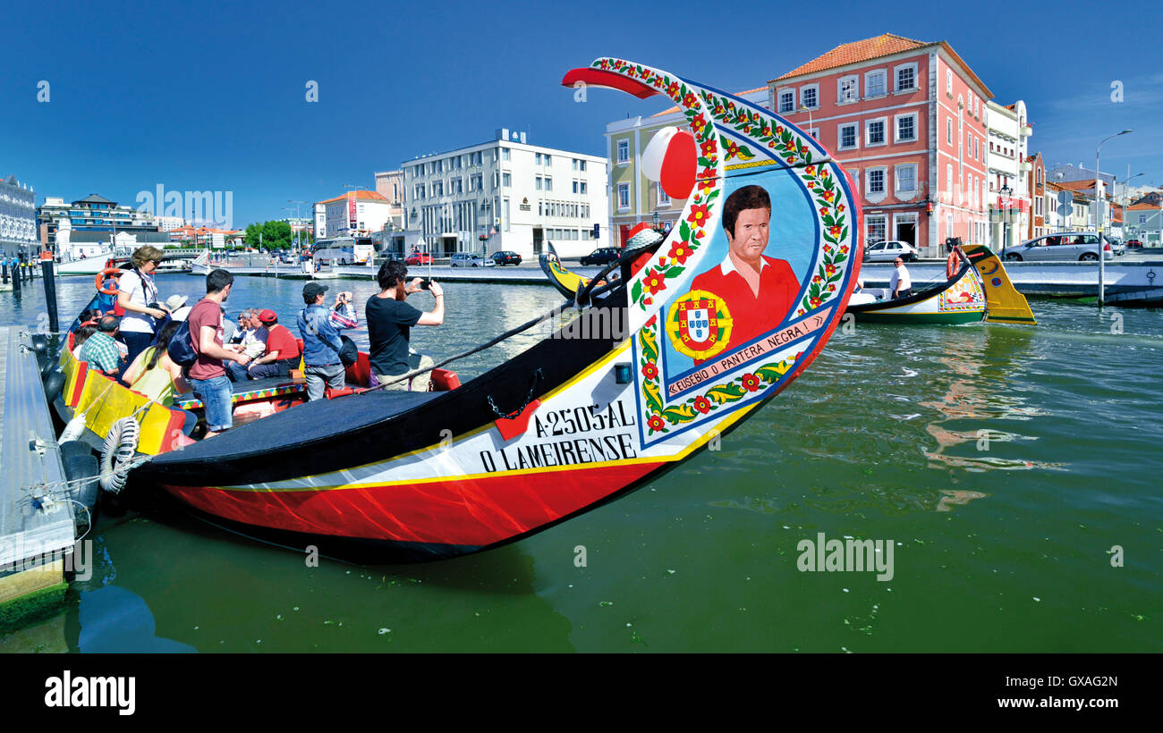 Portugal: Tourists taking pictures of boat passing their colorful Moliceiro boat in Aveiro Stock Photo