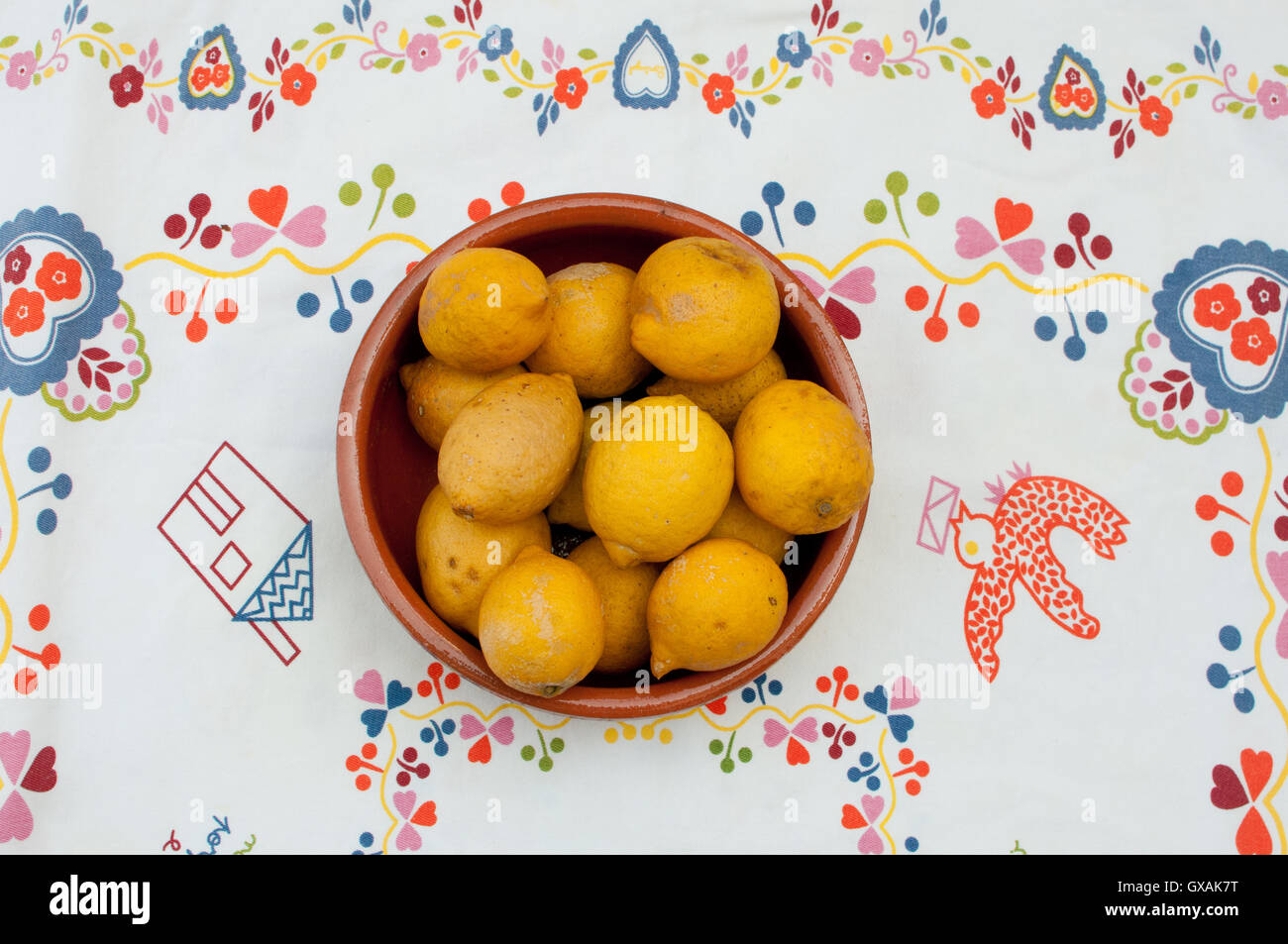 lemons in a bowl on a patterned tablecloth Stock Photo