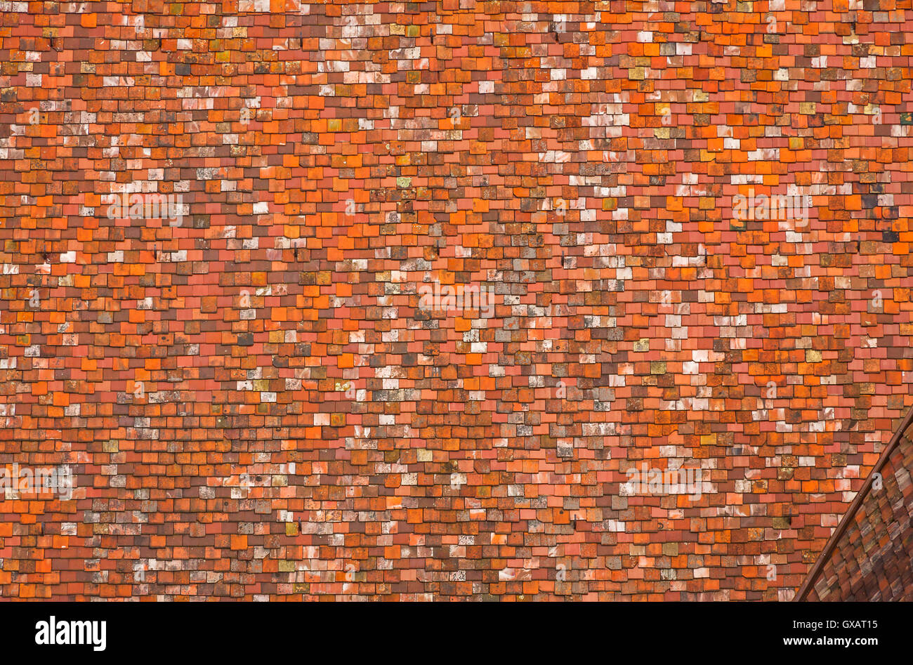 Bright background made of red roof tiles of an old gothic-style building Stock Photo